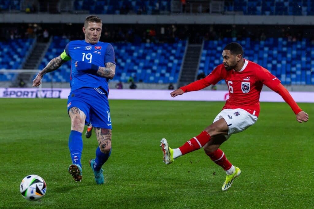 Im neuen EM Trikot der Slowakei: Der slowakische Mittelfeldspieler Juraj Kucka (L) und der österreichische Verteidiger Philipp Mwene kämpfen während des Freundschaftsspiels zwischen der Slowakei und Österreich in Bratislava, Slowakei, am 23. März 2024 um den Ball. (Foto von TOMAS BENEDIKOVIC / AFP)